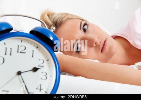 Junge Frau aegert sich beim Aufwachen und Aufstehen um 2.30 Uhr. Banque D'Images