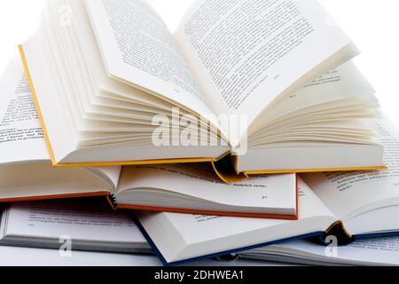 Buecher liegen aufgeschlagen auf weissem Hintergund Banque D'Images