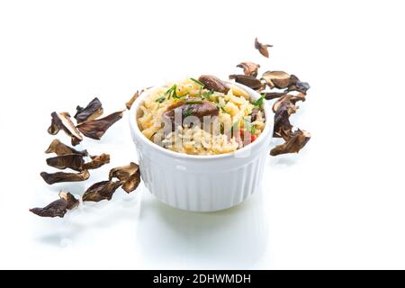 riz cuit avec champignons de forêt séchés, dans un bol isolé sur fond blanc Banque D'Images