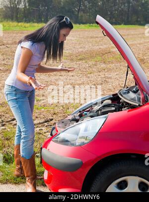 Junge Frau mit einer Motorpanne am Auto Banque D'Images