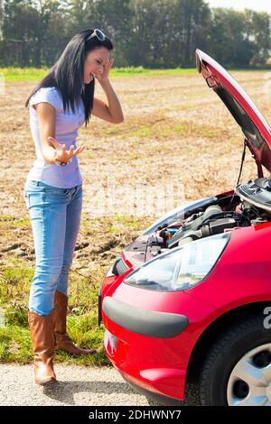 Junge Frau mit einer Motorpanne am Auto Banque D'Images