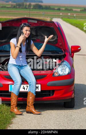 Junge Frau mit einer Motorpanne am Auto Banque D'Images