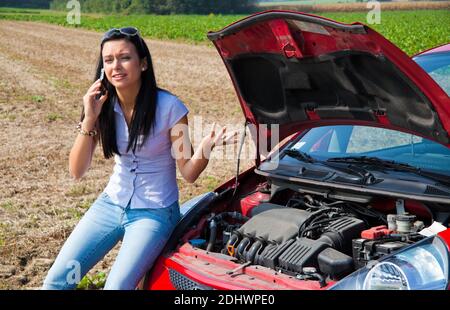 Junge Frau mit einer Motorpanne am Auto Banque D'Images