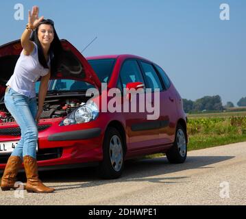 Junge Frau mit einer Motorpanne am Auto Banque D'Images