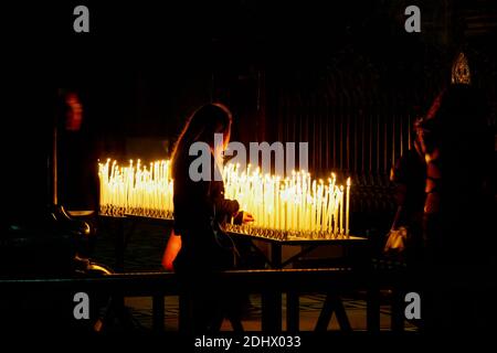 MILAN, ITALIE/EUROPE - 23 FÉVRIER : bougies allumées dans la cathédrale Duomo de Milan, Italie, le 23 février 2008. Une femme non identifiée Banque D'Images