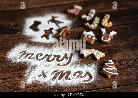 Biscuits de pain d'épice et texte de voeux de Joyeux Noël en sucre glace sur fond de table en bois Banque D'Images