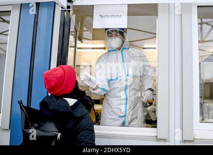 11 décembre 2020, Berlin : un membre du personnel médical effectue un prélèvement de gorge sur une jeune femme pour un test d'antigène du COV-SRAS au Centre d'essai rapide Corona Antigen de Mauerpark, dans le quartier berlinois de Prenzlauer Berg. Avec cette méthode, un résultat de test est disponible après 15-30 minutes. Photo: Britta Pedersen/dpa-Zentralbild/ZB Banque D'Images