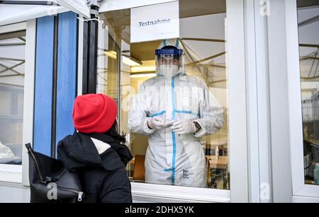 11 décembre 2020, Berlin : un membre du personnel médical effectue un prélèvement de gorge sur une jeune femme pour un test d'antigène du COV-SRAS au Centre d'essai rapide Corona Antigen de Mauerpark, dans le quartier berlinois de Prenzlauer Berg. Avec cette méthode, un résultat de test est disponible après 15-30 minutes. Photo: Britta Pedersen/dpa-Zentralbild/ZB Banque D'Images