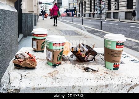 Tasses à café, bouteille d'alcool et litière laissées sur la chaussée Banque D'Images