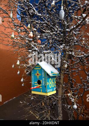 Des maisons d'oiseaux fabriquées à partir de plaques d'immatriculation d'automobiles recyclées pendent dans un petit arbre à Santa Fe, Nouveau-Mexique. Banque D'Images