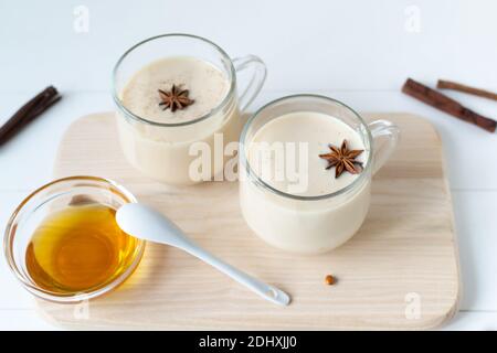 Deux tasses en verre de thé Masala avec épices et miel sur fond blanc. Boisson traditionnelle indienne. Orientation horizontale. Copier l'espace. Banque D'Images