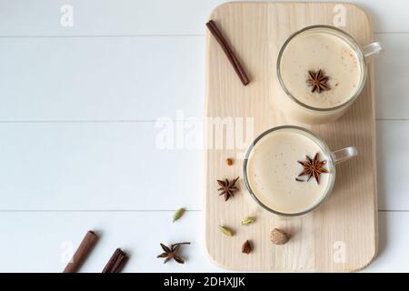 Deux tasses en verre de thé Masala aux épices sur fond blanc. Boisson traditionnelle indienne. Orientation horizontale. Copier l'espace. Vue de dessus. Banque D'Images