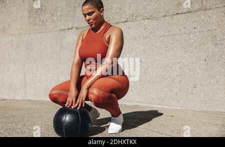 Femme en bonne santé s'exerçant avec Medicine ball. Taille plus féminine, vêtements de sport avec ballon de médecine. Banque D'Images