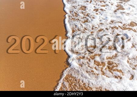 Le mot 2020 2021 est écrit en tant que texte sur le fond de plage de sable et vague de mousse Banque D'Images