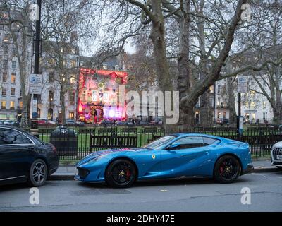 Londres, Grand Londres, Angleterre - 10 décembre 2020 : Ferrari garée à Berkeley Square avec la façade festive du club privé Annabels derrière, Mayfair. Banque D'Images