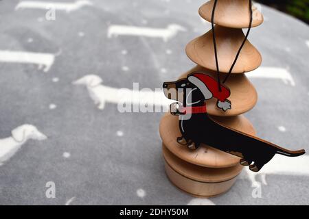 Une décoration de Noël traditionnelle pour les amoureux de Dachshund design classique en bois et ruban rouge festif et le collier Banque D'Images