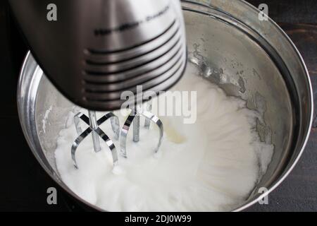 Battre les blancs d'oeufs pour faire de la meringue: Blancs d'oeufs qui ont été battus dans un mélangeur de stand jusqu'à ce qu'ils soient molletonnés Banque D'Images