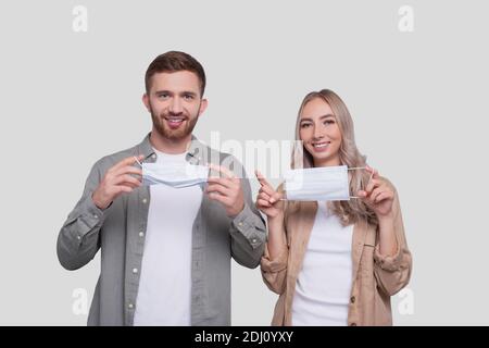 Couple met sur le masque médical debout isolé. Protection de la santé, soins médicaux, couple, famille, concept de virus Banque D'Images