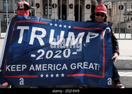 Atlanta, Géorgie, États-Unis. 12 décembre 2020. Lors d’un rassemblement pro-Trump à Atlanta, deux manifestants arborent un drapeau qui se lit comme TRUMP 2020 KEEP AMERICA GREAT sur les marches du Capitole de l’État de Géorgie. Le rassemblement a eu lieu un jour après que la Cour suprême des États-Unis a rejeté une poursuite intentée par l'État du Texas, demandant au tribunal d'annuler les résultats des élections en Géorgie, en Pennsylvanie, au Michigan et au Wisconsin ; quatre États sur le terrain de bataille qui ont été remportés par le président élu Joe Biden lors de l'élection présidentielle de 2020. Crédit : John Arthur Brown/ZUMA Wire/Alay Live News Banque D'Images