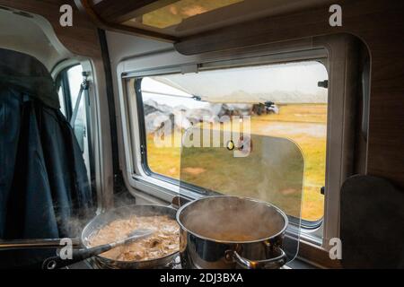Spaghetti à la crème crémeuse cuit sur cuisinière à gaz à Campervan, Moskenes Camping, Lofoten, Norvège Banque D'Images