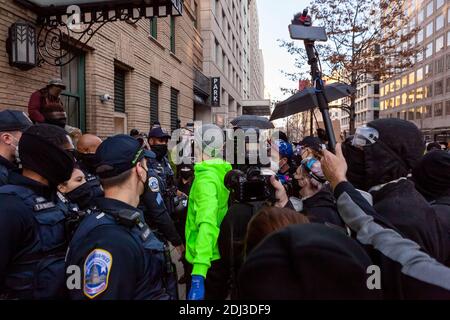 Washington, DC, Etats-Unis, 12 décembre 2020. Photo : un manifestant contre le racisme tente avec succès de séparer la politique en colère des manifestants en colère pour que chaque personne ait l'occasion de se rafraîchir. Cela s'est produit lorsque de nombreux partisans de Trump et des partisans de la suprématie blanche sont venus en ville pour le million MAGA March II pour protester contre ce qu'ils pensent à tort comme une élection truquée. Crédit : Allison C Bailey/Alay Live News Banque D'Images