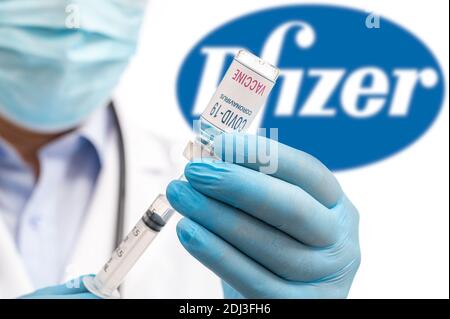 Séoul, Corée du Sud-décembre 2020 : concept de vaccin COVID-19. Les mains du personnel médical tenant la seringue et le flacon, le logo de la société Pfizer sur l'ba Banque D'Images