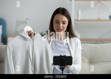 Gros plan une jeune femme souriante qui photographie des vêtements passe en revue la vidéo Banque D'Images