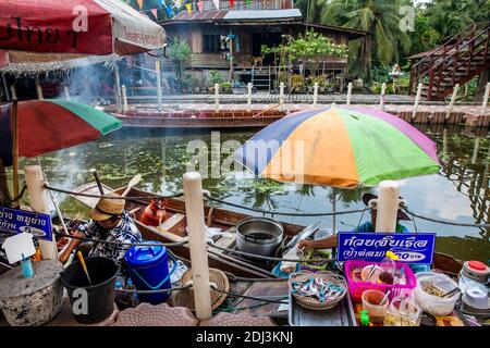 Les femmes à bord de san Pans cuisinent et servent une variété d'en-cas et de plats de rue dans le marché flottant de Damnoen près de Bangkok. Banque D'Images