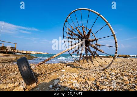 Parasol abandonné sur une plage rocheuse située contre la mer. Pris une plage à Protaras, Chypre. Banque D'Images