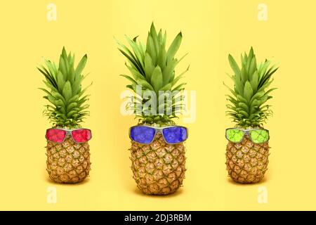 Trois ananas avec lunettes de soleil sur fond jaune Banque D'Images