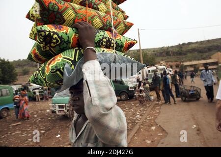 Marché principal de Bamako le Grand Marche.marchand portant des pilows sur sa tête. Banque D'Images