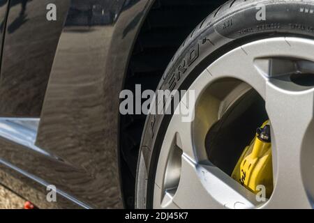 Gros plan de la roue arrière, du pneu et du passage de roue sur une voiture de sport Lamborghini Gallardo V10 de première génération noire métallique exposée au soleil Banque D'Images
