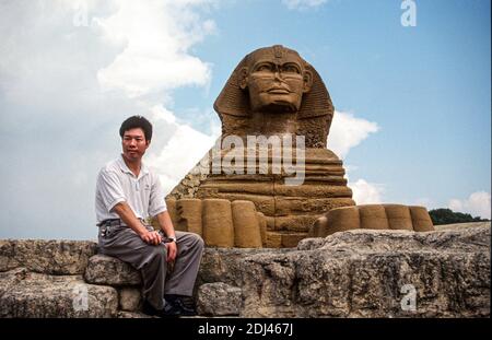 Homme assis par SSpinx réplique, fenêtre du parc à thème du monde, Shenzhen, Guangdong, Chine, 1995 Banque D'Images