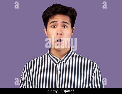 Grimace asiatique effrayé, choqué au pourpre studio Banque D'Images