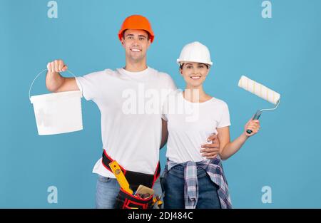 Rénovation de la maison. Portrait de couple souriant avec outils de peinture, prêt pour réparation Banque D'Images