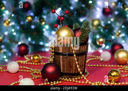 Boules de Noël et branche d'arbre de Noël en seau avec perles sur fond de bokeh. Fond de Noël ou carte de Noël. Concept nouvel an ou Noël. Banque D'Images