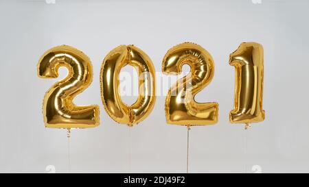 ballons gonflables de couleur dorée en feuille d'aluminium, les numéros date 2021 remplis d'hélium sur un ruban isolé sur fond blanc. Bonne année 2021 Banque D'Images