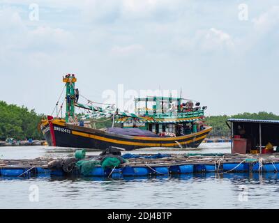 Bateau de pêche descendant la rivière Dinh près de Vung Tau dans la province de Bang Ria-Vung Tau, au sud du Vietnam. La pisciculture au premier plan. Banque D'Images