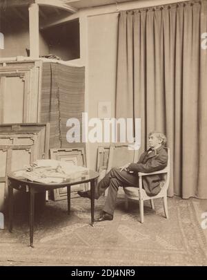 Whistler assis dans une chaise dans son studio de Paris (rue notre-Dame-des-champs), Paul François Arnold Cardon, appelé 'dornac', 1859–1941, français, 1893, imprimé albumine sur papier fin, lisse, vélin, feuille: 10 1/4 x 8 pouces (26 x 20.3 cm) et support: 17 × 14 pouces (43.2 × 35.6 cm), artiste, livres, bouteille, boîte, chaise, manteau, col, rideaux, tiroir (élément de mobilier), homme, peintre, peintures, papier, portrait, printMaker, chevrons, tapis, chaussures, studio (espace de travail), table, cravate, pantalon, gilet, Europe, France, Paris Banque D'Images