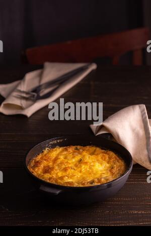 Frittata au fromage, mozzarella et potiron dans une poêle en fonte sur fond de bois Banque D'Images