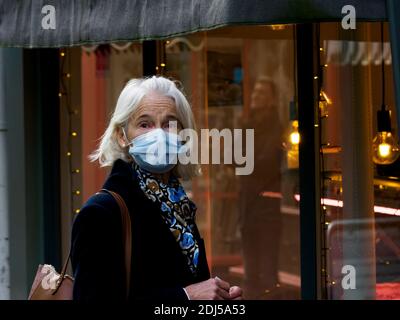 Femme élégante et âgée portant un masque shopping de Noël, Bideford, Devon, Royaume-Uni 2020 Banque D'Images