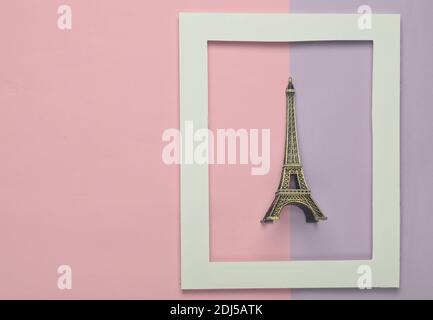 Statuette souvenir de la tour Eiffel dans un cadre blanc sur fond pastel coloré. Tendance minimaliste. Vue de dessus. Banque D'Images