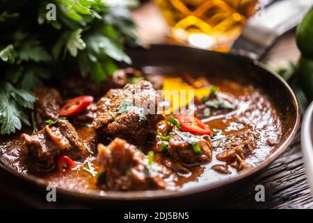 Plats cuits lentement sous forme de goulash de bœuf, de veau ou de porc réchauffés dans une casserole d'époque. Banque D'Images