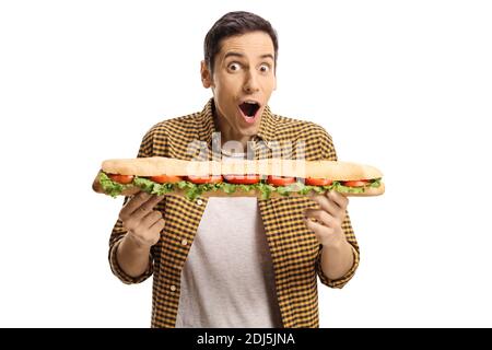 Jeune homme mangeant un long sandwich savoureux dans une baguette isolé sur fond blanc Banque D'Images