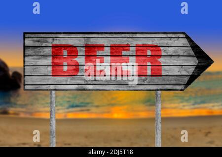 Panneau de bois de bière rouge avec sur un fond de plage Banque D'Images