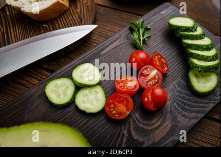 Tomates et concombres coupés, fond en bois Banque D'Images