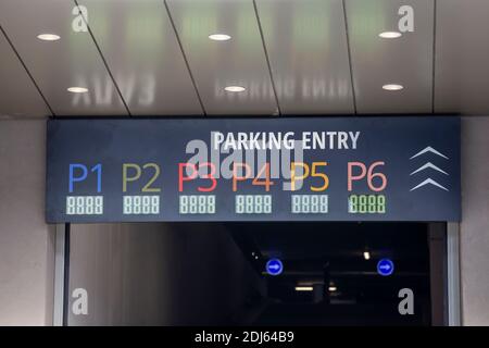 Entrée du parking en garage avec les panneaux indiquant les numéros au niveau de l'étage au-dessus. Banque D'Images