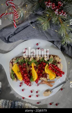 Gâteau de Noël à la cannelle fait maison avec des fruits et des biscuits au spekulatius crème sur un comptoir de cuisine. Banque D'Images