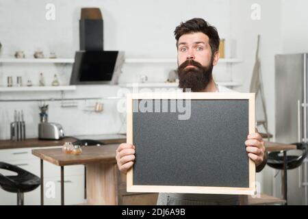 votre texte ici. brutal hipster homme tenant le tableau blanc, espace copie. recherche d'emploi. il y a des postes vacants. vente de shopping et réductions. menu chef dans la cuisine. regardez là-bas. tableau noir pour la publicité. Banque D'Images