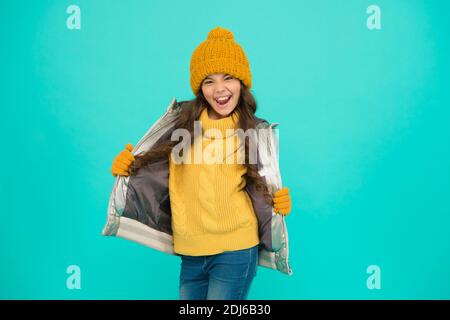 une adolescente souriante dans une veste matelassée ou matelassée prête à passer des vacances d'hiver et des vacances dans le confort et la chaleur, insouciante et amusante. Banque D'Images